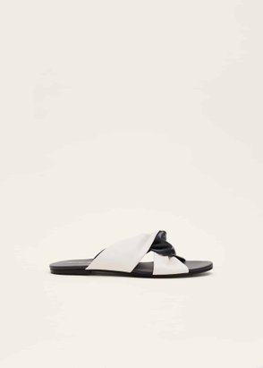 White leather sandals with a black knotted strap.
