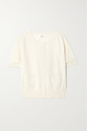 Cream-colored, ribbed cardigan with button closure and pockets.