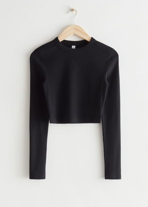Black ribbed crop top on a light wood hanger