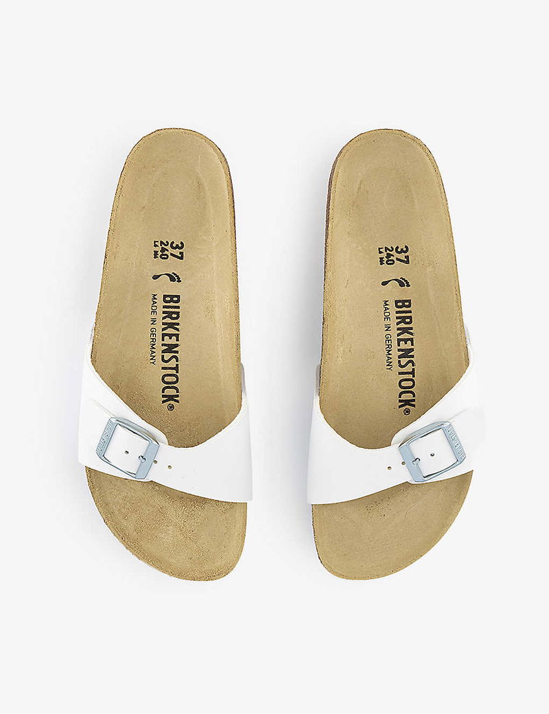 White Birkenstock Arizona sandals with leather straps and footbed details.