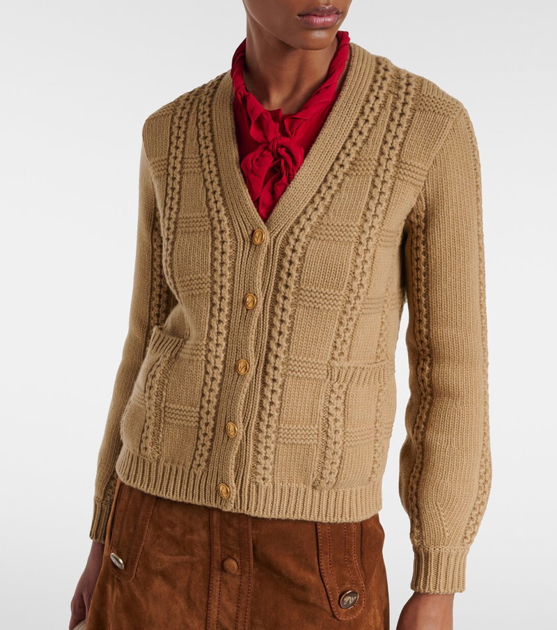 Camel cable-knit cardigan with red silk scarf, worn by a model.