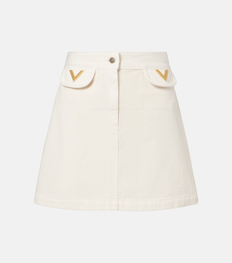 Cream-colored denim skirt with gold V-shaped embellishments