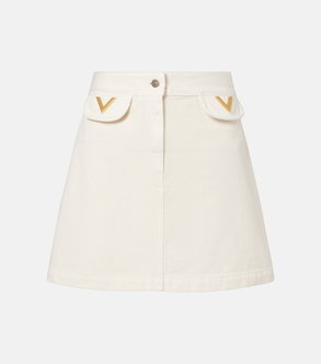 Cream-colored denim skirt with gold V-shaped embellishments