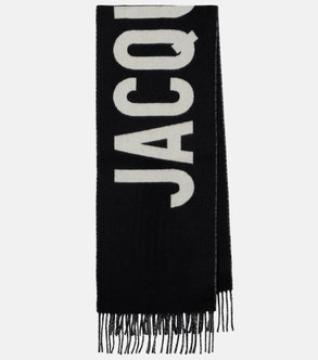 Black scarf with white JACQUEMUS logo and fringed ends.
