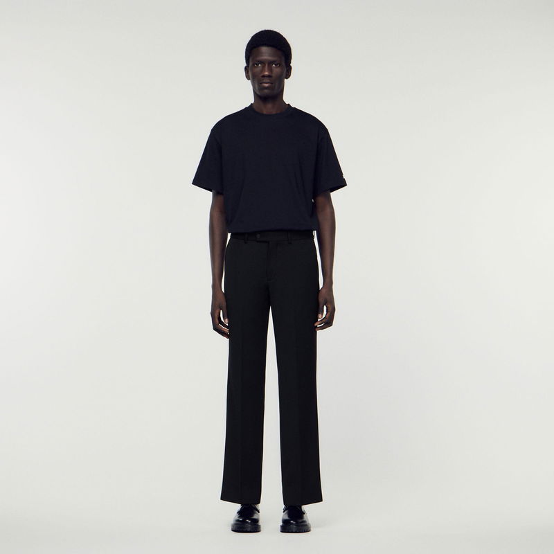 Black t-shirt and trousers on a man.