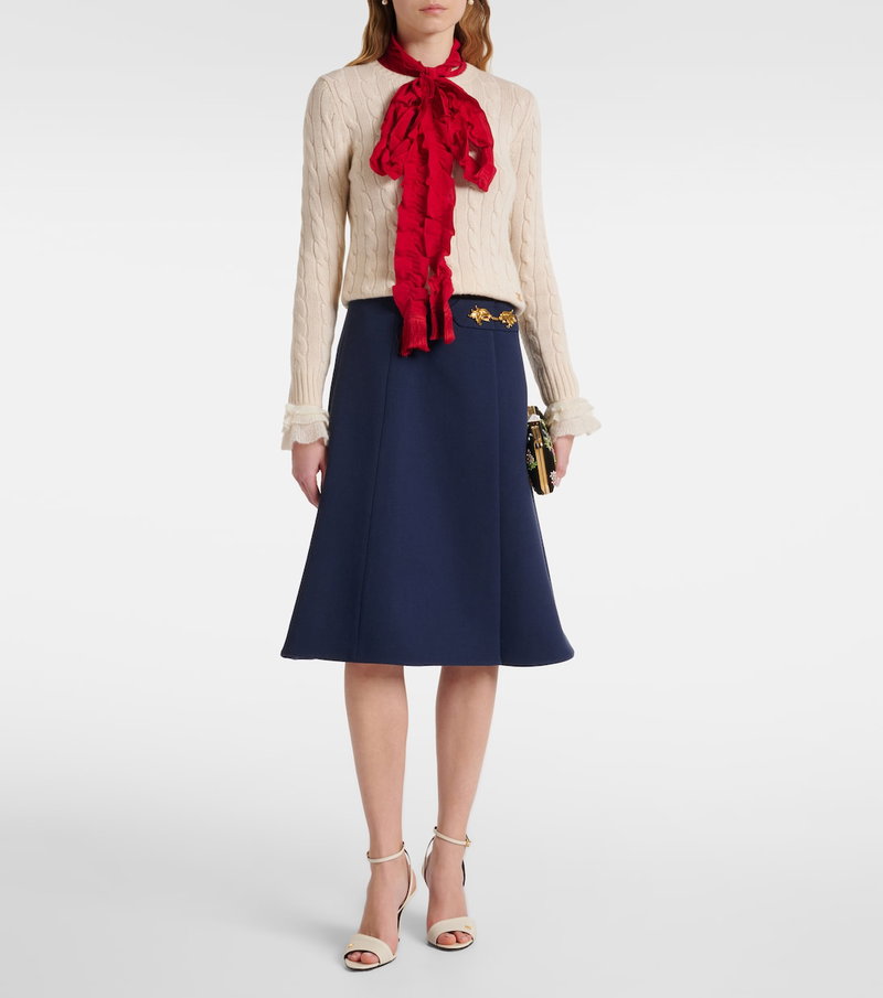 Valentino beige cable-knit sweater with red silk scarf and navy pleated skirt