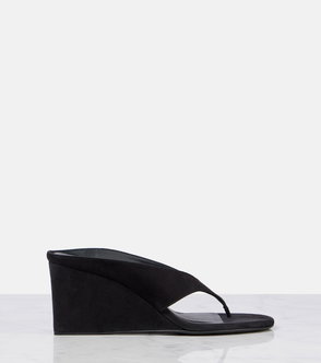 Black suede wedge flip-flop on a marble surface