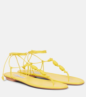 Yellow leather sandals with braided ankle ties.