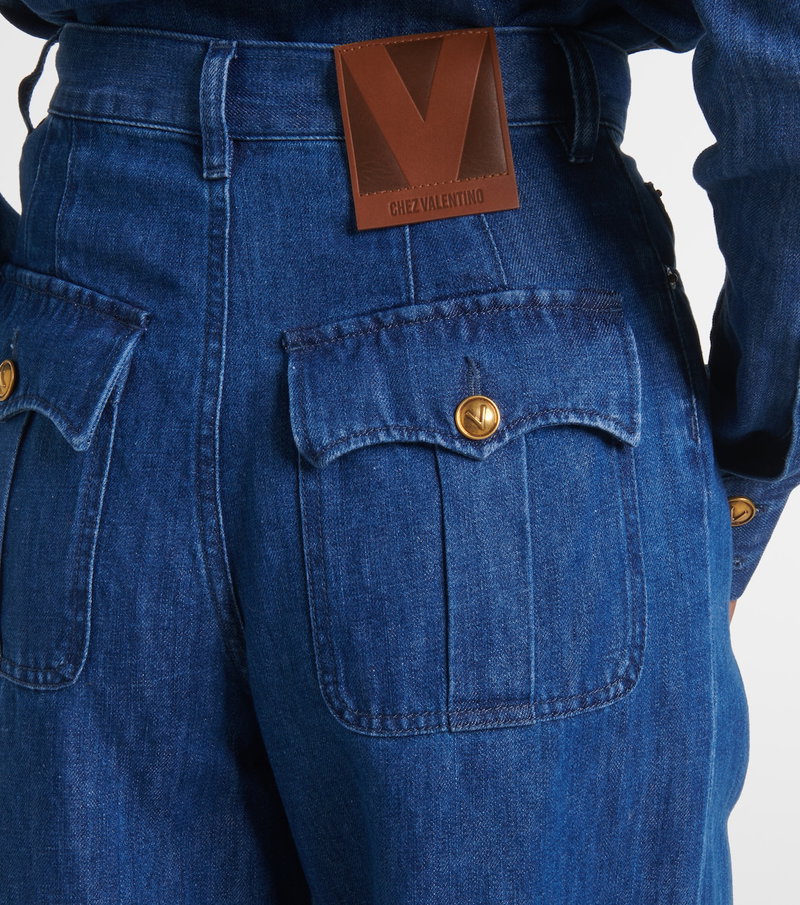 Blue denim pants with a brown V logo patch on the back pocket.