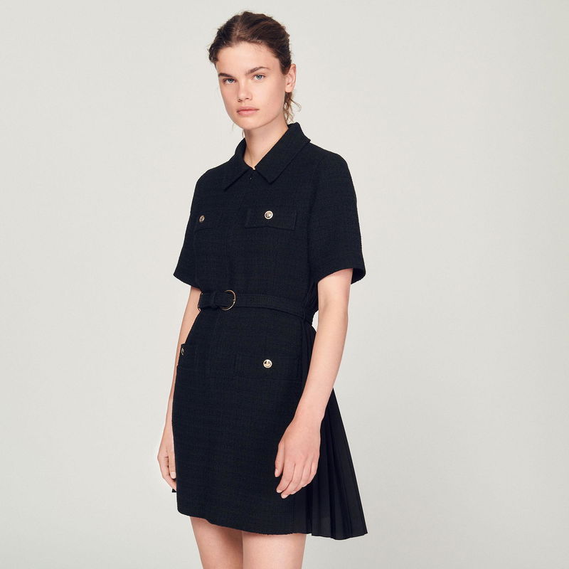 Black tweed dress with belted waist and pleated hem.