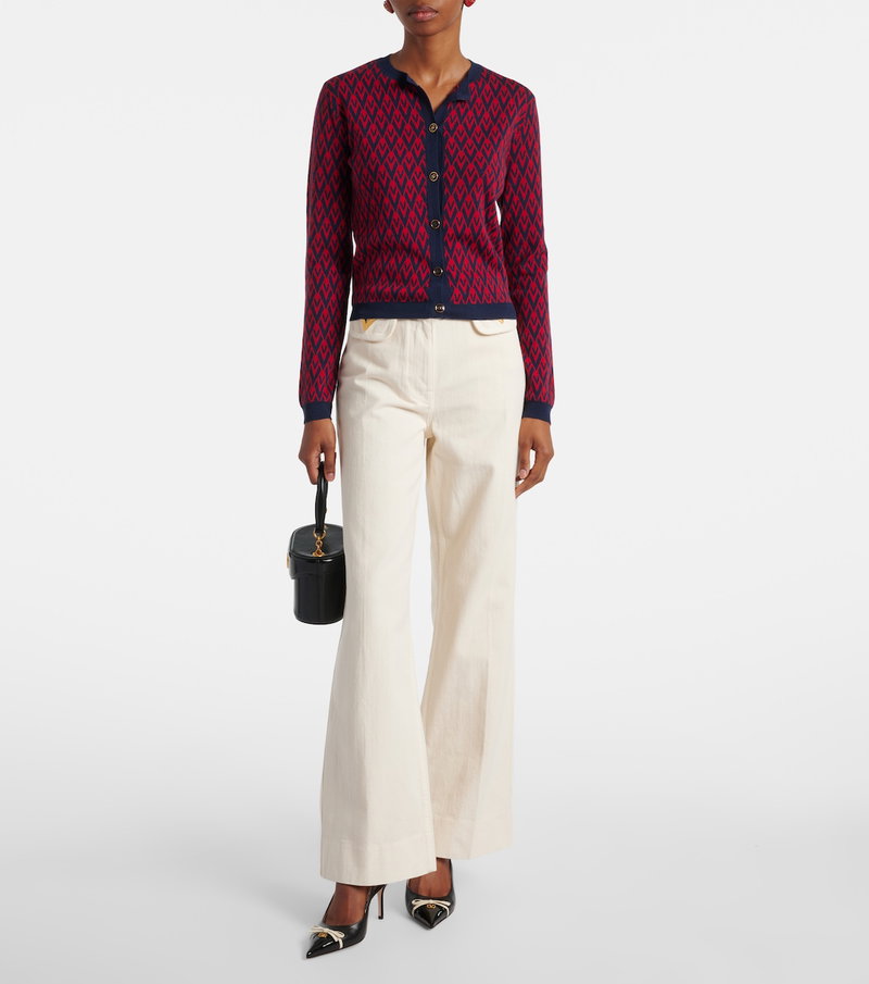 Valentino navy and red geometric knit cardigan with woman wearing wide-leg trousers and heels.