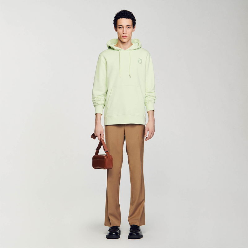 Light green SANDRO hoodie worn by a man with brown trousers and shoes.