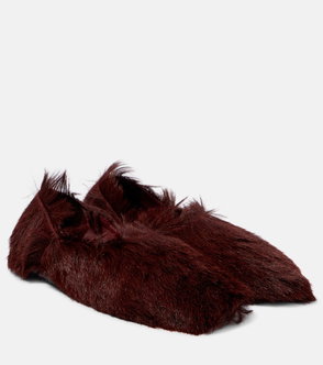 Dark maroon fur-trimmed slippers on a neutral background