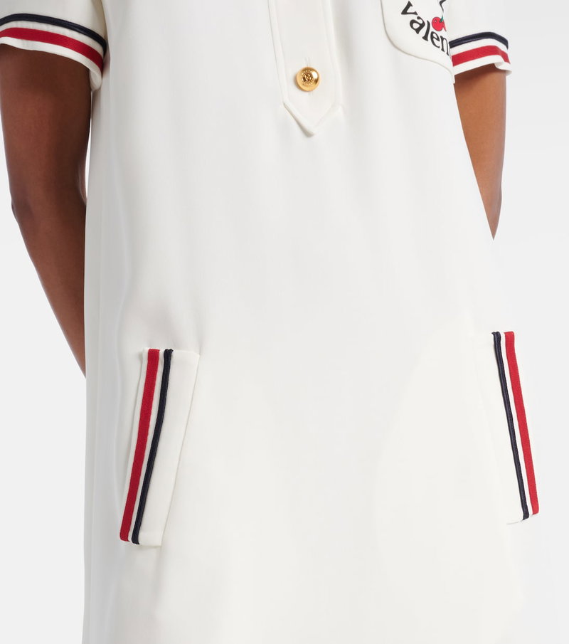 White polo shirt with red and blue stripes and a Valentino heart logo.