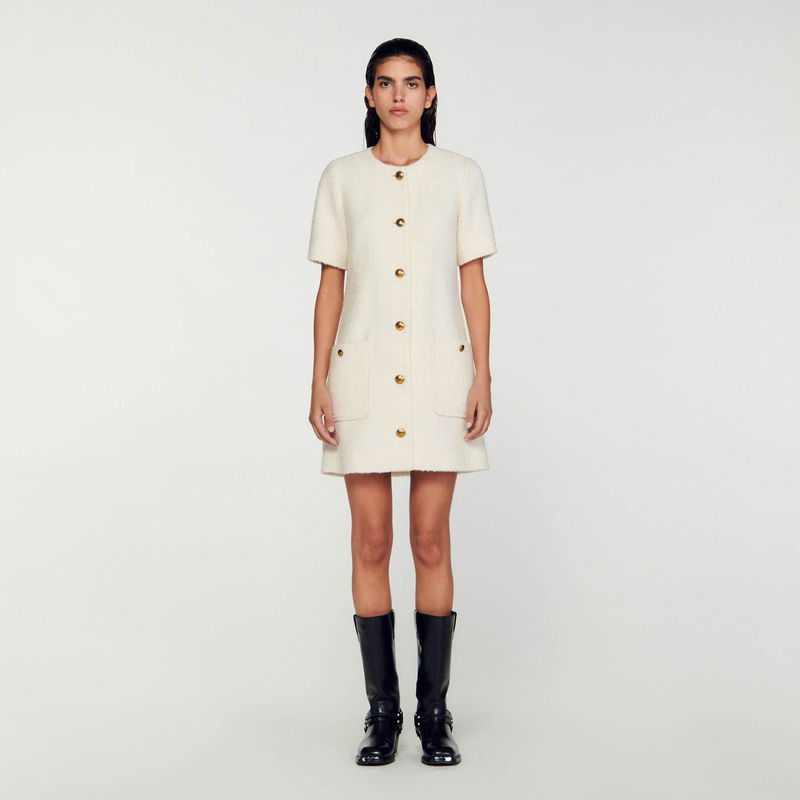 Cream tweed dress with gold buttons and black boots.