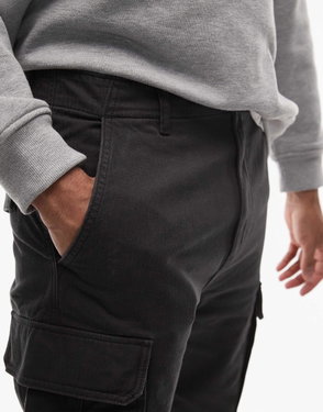 Dark gray Tommy Jeans cargo pants with pockets, worn by a person.