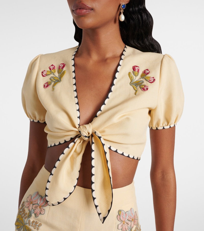 Cream cropped top with floral embroidery and tie front.