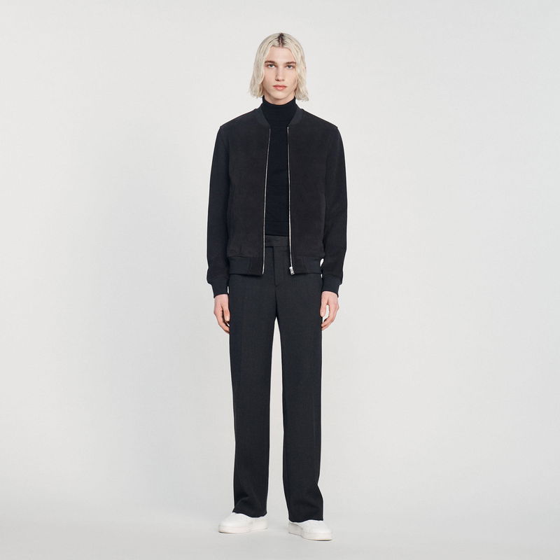 Black bomber jacket and trousers on a model.