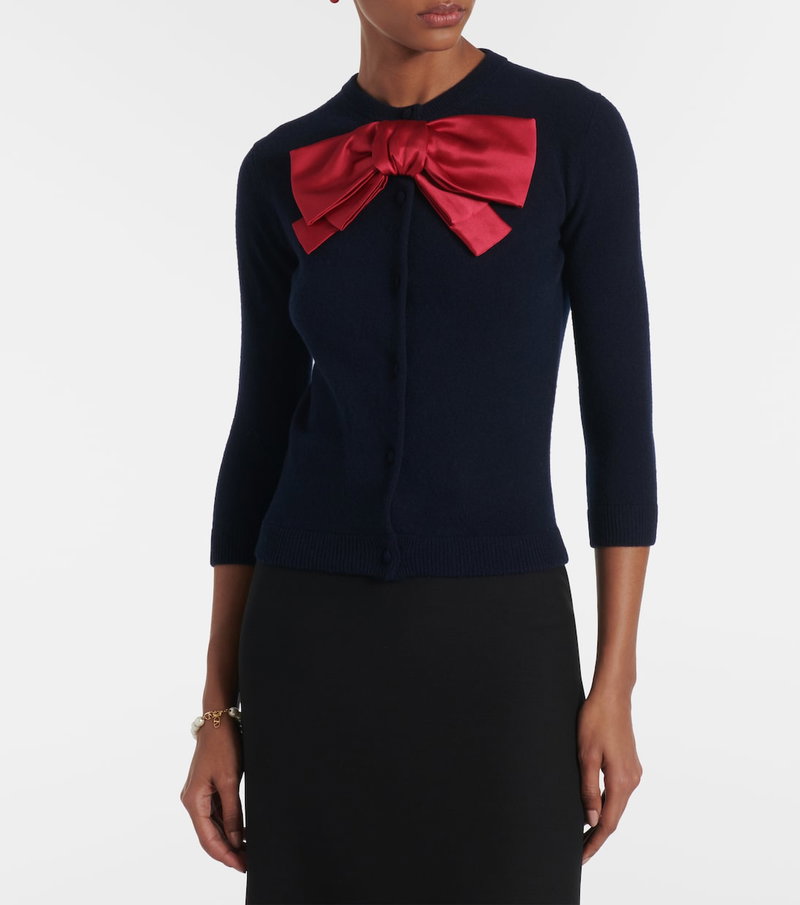 Navy cardigan with a large red satin bow.