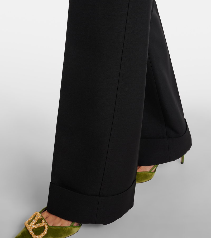 Black wide-leg trousers with gold chain embellishment.