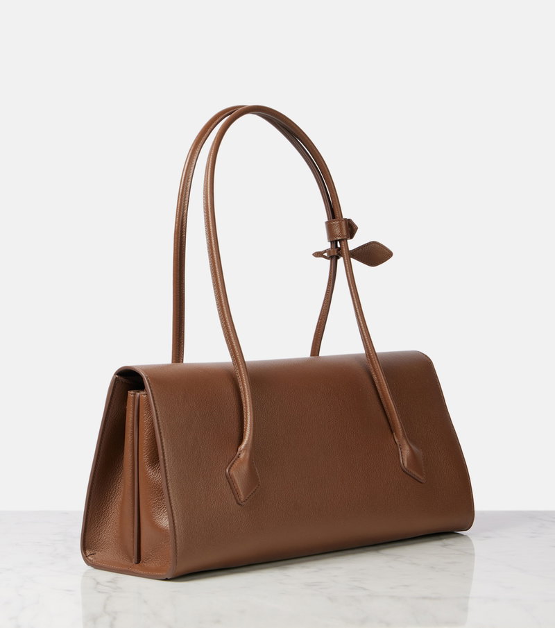 Brown leather tote bag with a ribbon tie and handles.