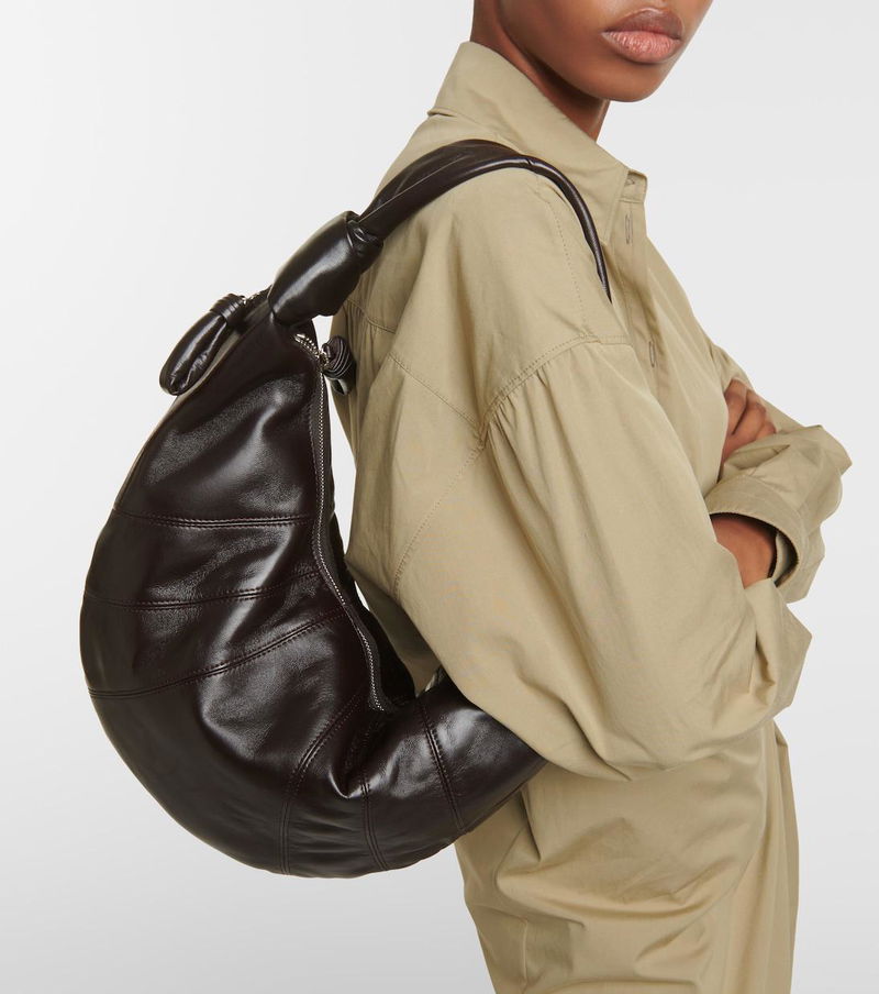 Brown leather slouch bag worn by a model.