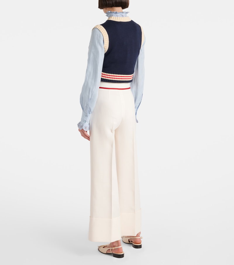 Navy and blue ribbed vest with ruffled trim, paired with wide-leg trousers.