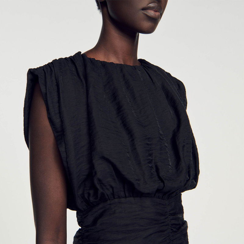 Black satin draped top with wide sleeves.