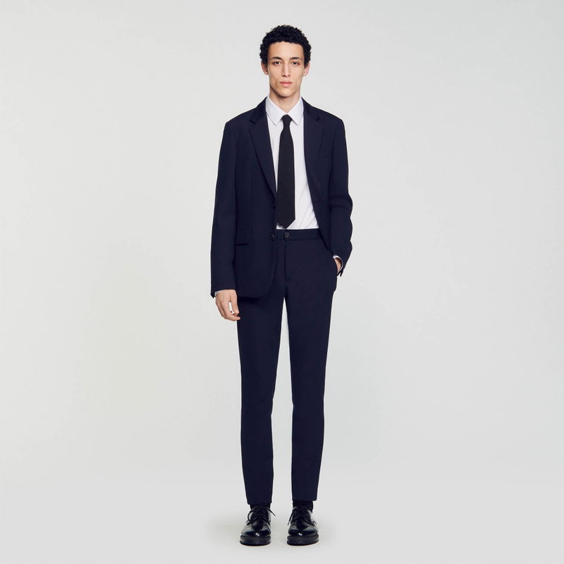 Man wearing a navy suit and tie.
