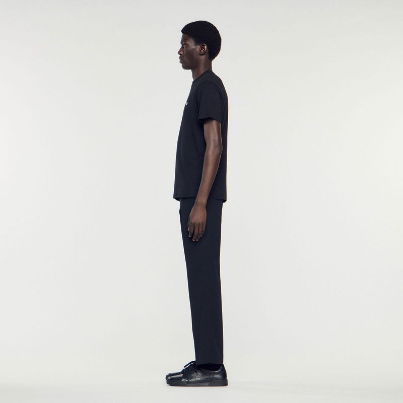 Black SANDRO t-shirt and trousers on a model.