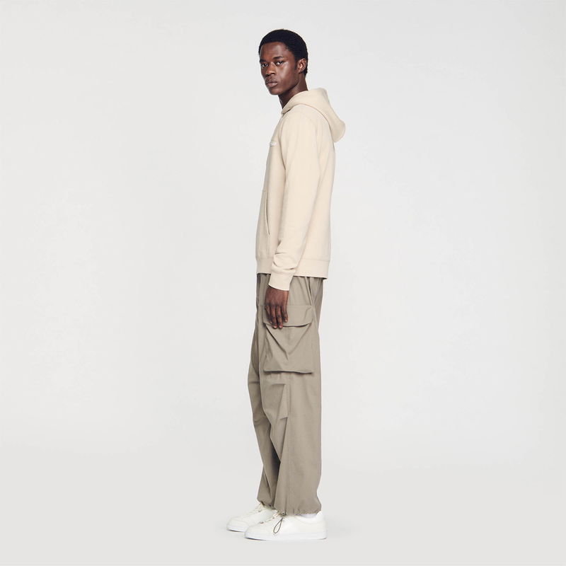 Sandro man in beige hoodie and cargo pants