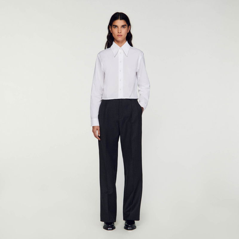 SANDRO: Woman in white shirt and grey pinstripe trousers