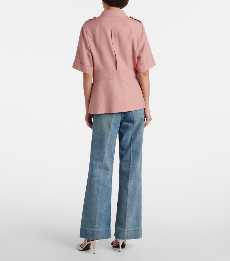 Pink cotton shirt with gold buttons, worn by a model.