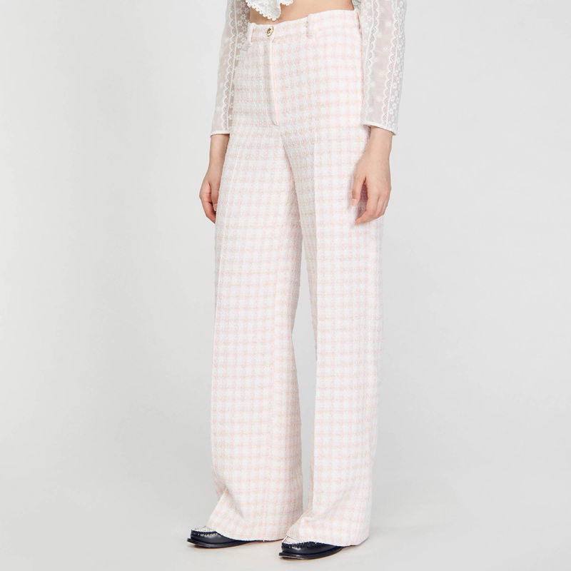 Pale pink and white checkered wide-leg trousers with a black leather belt.