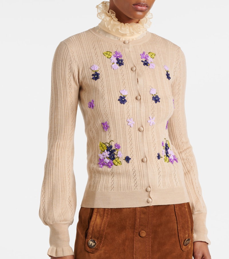 Embroidered cardigan with floral details and ruffled collar.