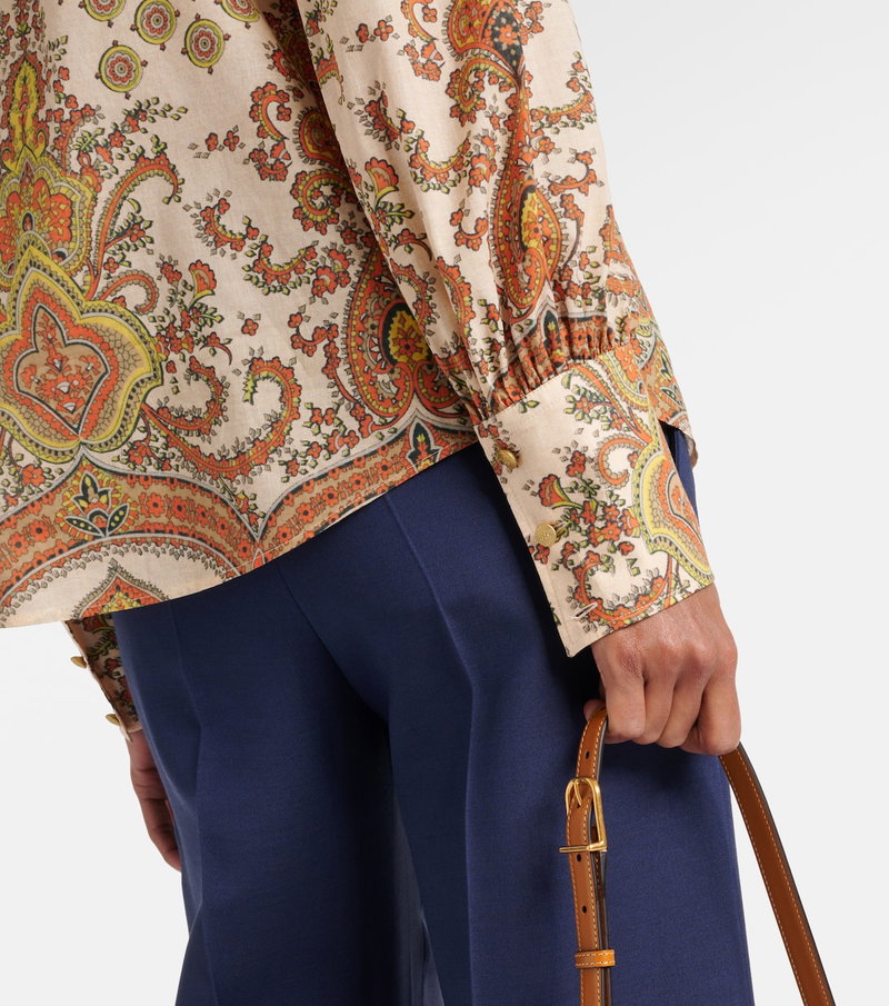 Valentino paisley blouse with navy trousers and belt.