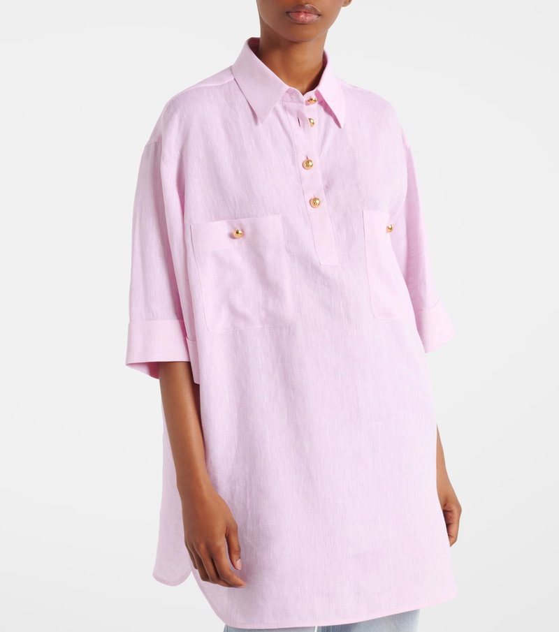 Pink linen shirt with gold buttons, worn by a model.