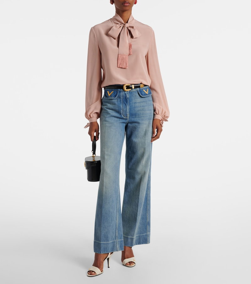 Pink Valentino blouse with a tied bow, paired with wide-leg jeans and a crossbody bag.