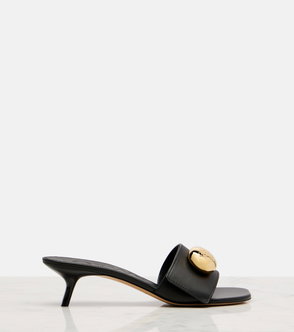 Black leather mules with a gold buckle detail.