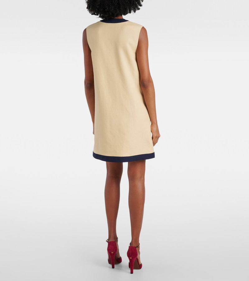 Cream and navy sleeveless dress with a model wearing red heels