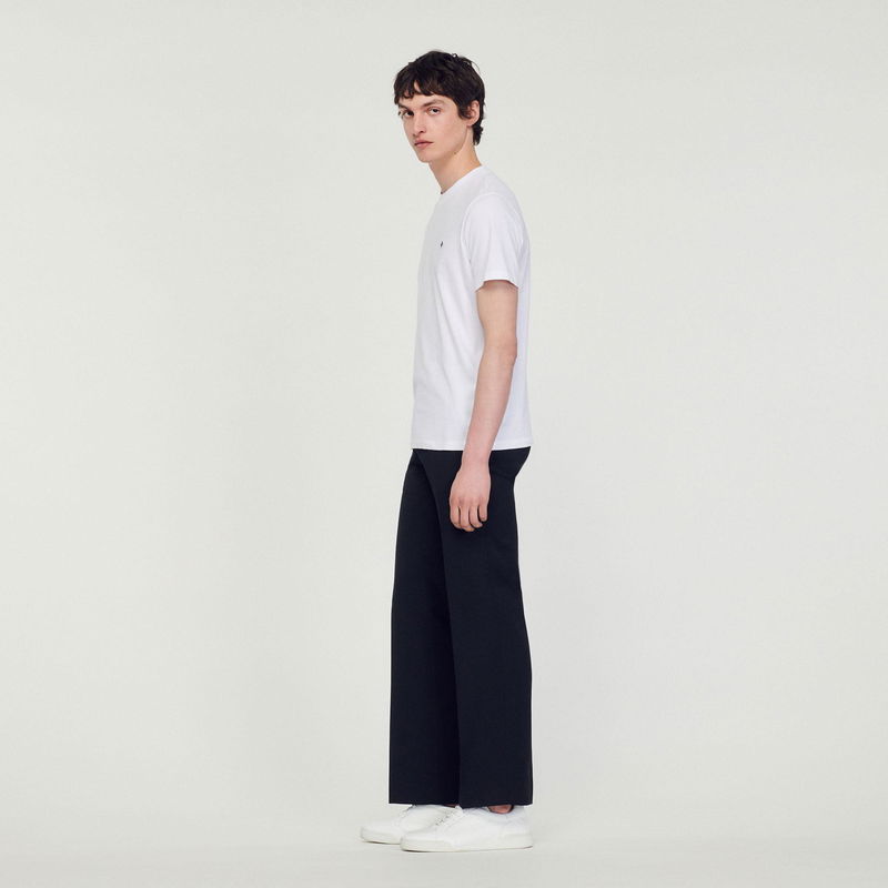 Sandro man in white t-shirt and black trousers