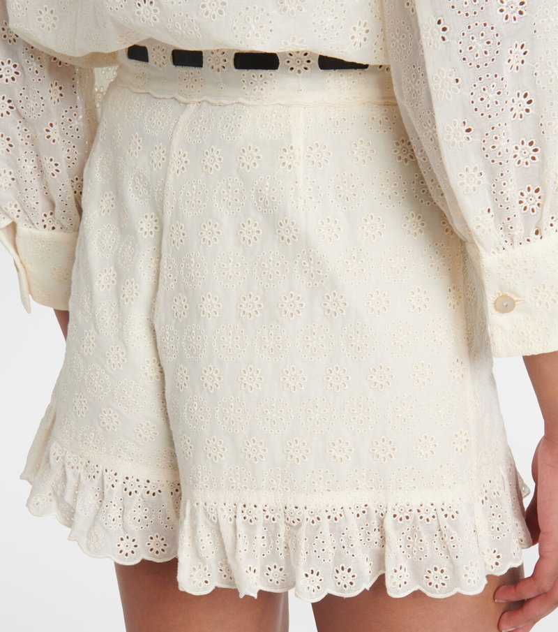Cream floral-cutout shorts with a black belt.
