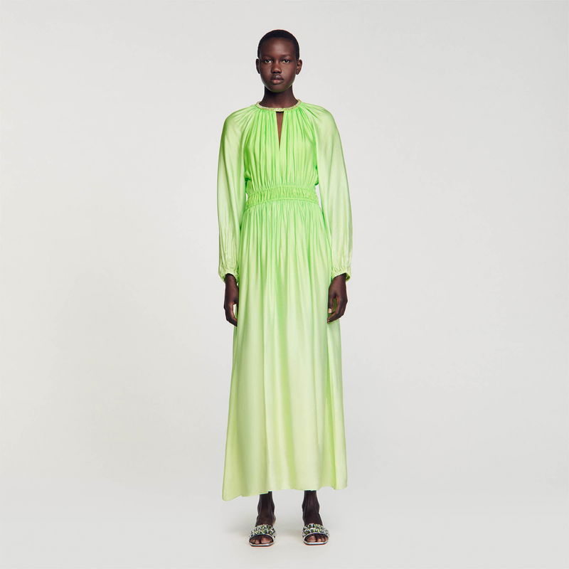Satin green dress with long sleeves, worn by a model.