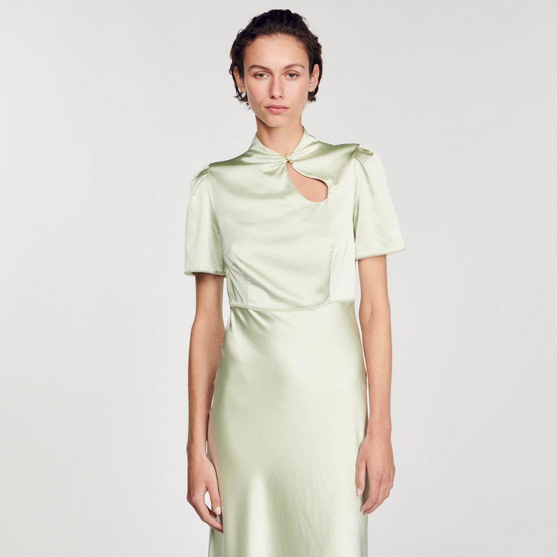 Pale green satin dress with a high neck and cut-out sleeves.