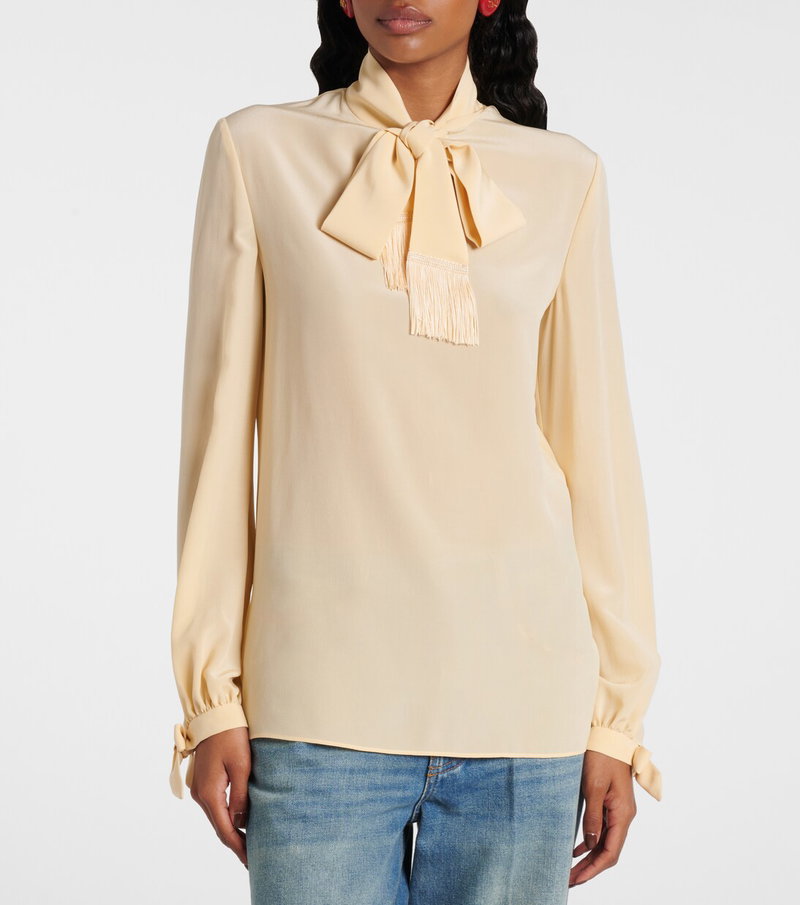 Cream silk blouse with a bow tie and fringe detail.