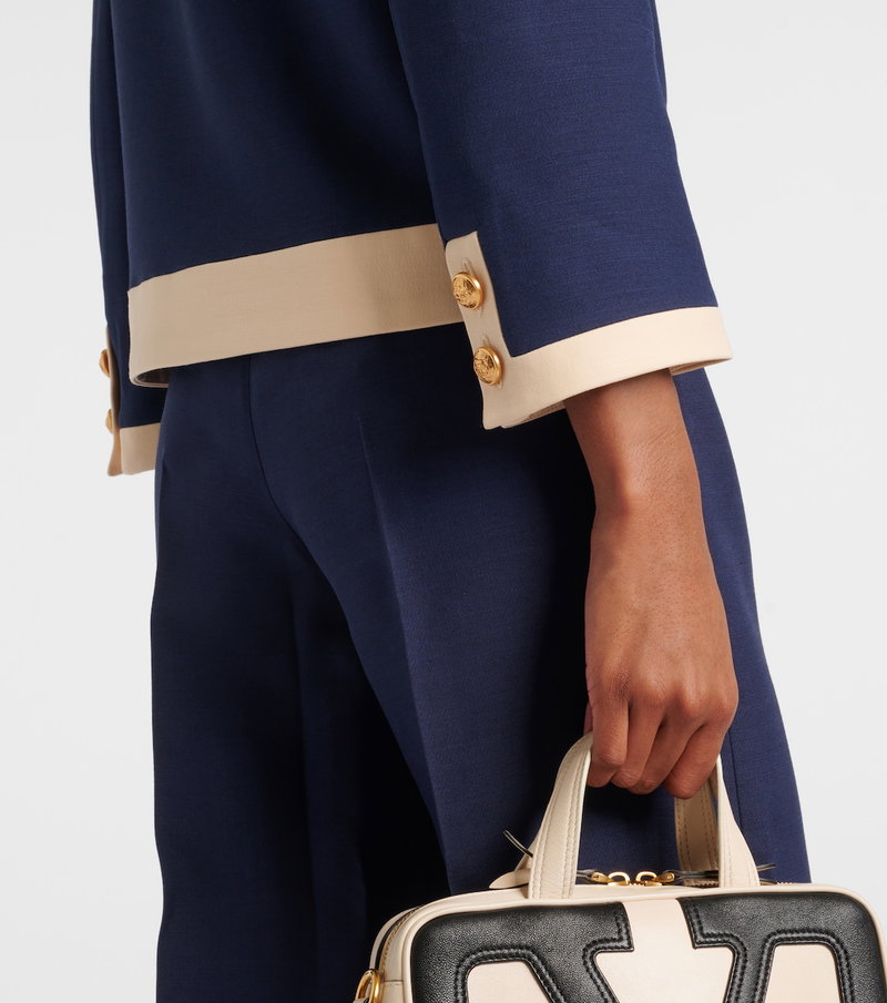 Valentino navy and cream tailored suit with a handbag.