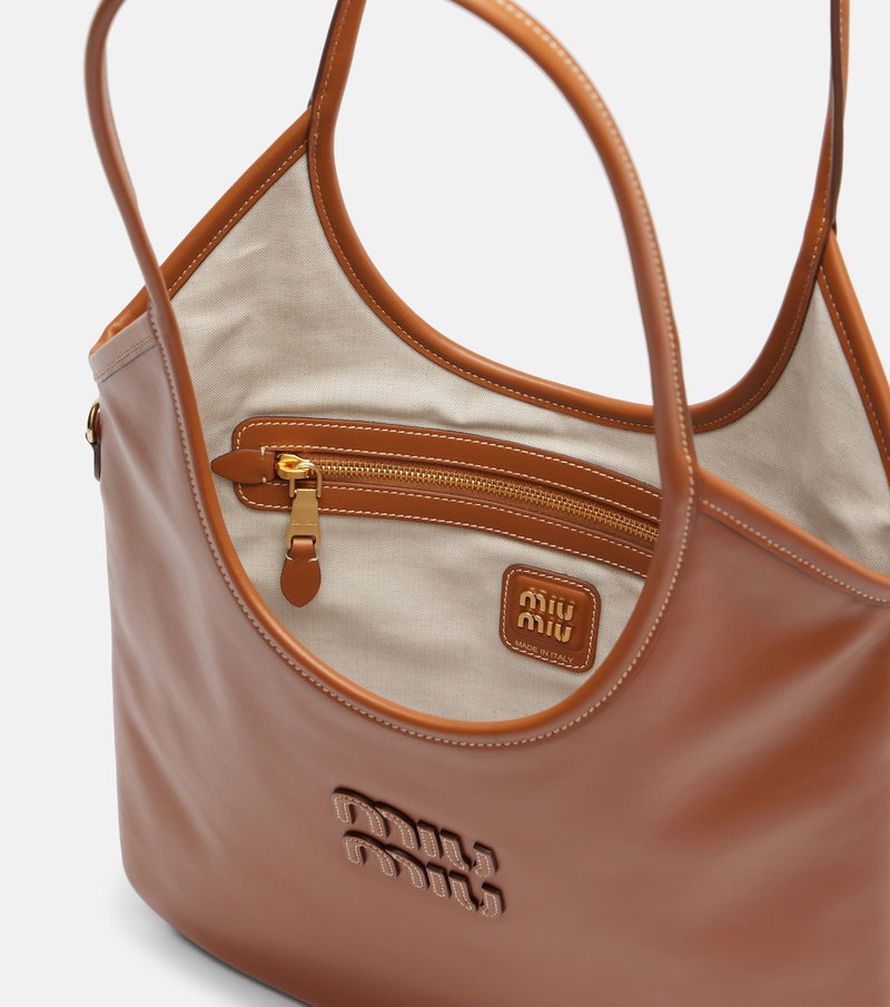 Brown leather tote bag with beige lining and gold zipper.