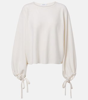Cream-colored, oversized sweater with balloon sleeves and drawstring cuffs.