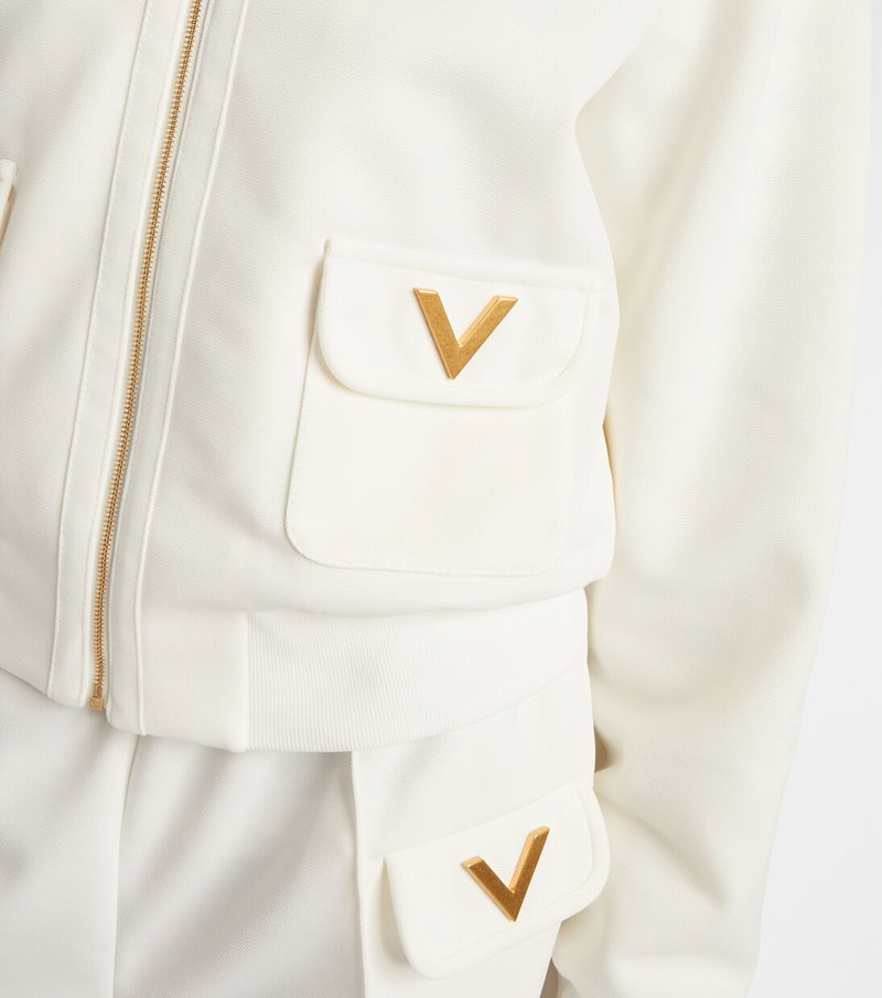 Cream-colored Valentino zip-up jacket with gold V logo pockets.