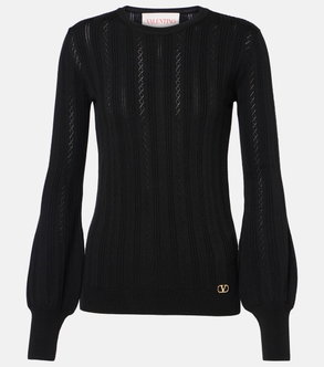 Black ribbed knit sweater with balloon sleeves and a gold Valentino logo.